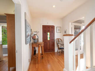 Step into this charming entryway featuring a beautiful wooden front door with stained glass accents.