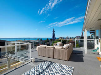 Enjoy breathtaking ocean and city views from this expansive rooftop deck, perfect for entertaining or relaxing.