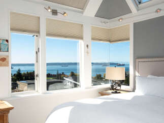 Wake up to breathtaking water views from this stunning bedroom, featuring expansive windows that flood the space with natural light.