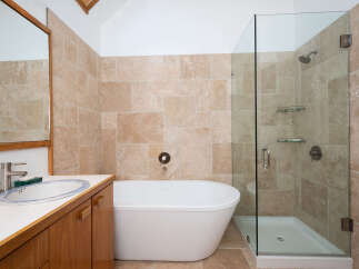 Experience luxury in this stunning bathroom featuring a freestanding soaking tub and a spacious glass-enclosed shower.