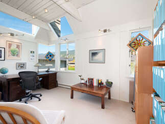 This bright and airy home office features a spacious desk with an ergonomic chair, perfect for productive work sessions.