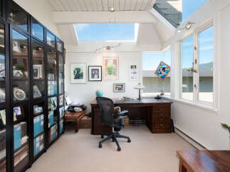 This home office features a spacious wooden desk with an ergonomic chair, perfect for productivity.