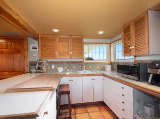 Discover this charming kitchen featuring warm wooden cabinetry and a spacious countertop, perfect for meal preparation and casual dining.