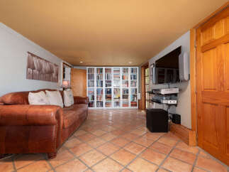 This inviting living space features a plush brown leather sofa complemented by a large floral wall art.