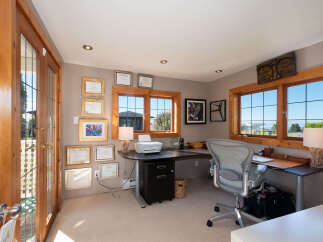 This home office features a spacious L-shaped desk with a printer and a comfortable ergonomic chair, perfect for productivity.