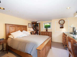 This charming bedroom features a cozy wooden bed with crisp white linens, perfect for a restful night's sleep.