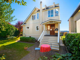 Charming home with a welcoming front porch and a spacious backyard perfect for outdoor entertaining.