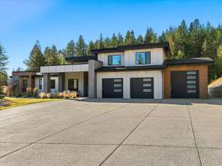 Experience modern luxury in this stunning multi-level home, featuring a sleek white exterior with wood accents and a dramatic cantilevered roofline.
