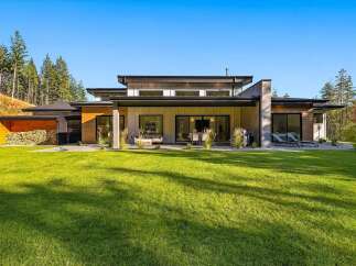 Experience modern luxury in this stunning home featuring expansive glass doors and windows that seamlessly blend indoor and outdoor living.