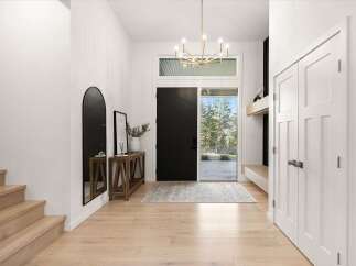 Step into a bright and airy entryway featuring a modern gold chandelier and a sleek black front door.