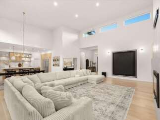 Experience modern luxury in this expansive living area, featuring soaring vaulted ceilings and abundant natural light from clerestory windows.