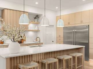Experience modern luxury in this stunning kitchen, featuring sleek light wood cabinetry and a spacious waterfall island perfect for entertaining.