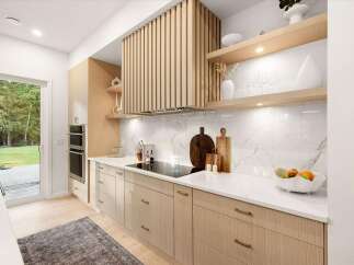Experience modern living in this stunning kitchen featuring sleek, light wood cabinetry and a unique slatted range hood.