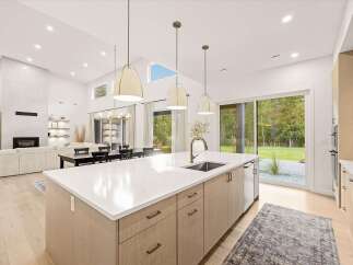 Experience modern luxury in this open-concept living space, featuring a stunning gourmet kitchen with a large island and sleek cabinetry.