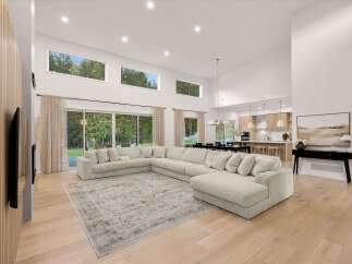 Experience modern luxury in this expansive open-concept living space, featuring soaring vaulted ceilings and floor-to-ceiling windows that flood the area with natural light.