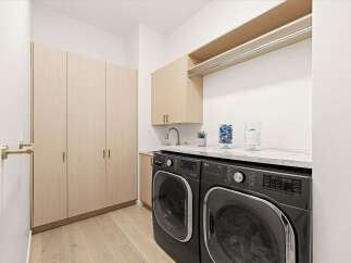 Discover this modern laundry room featuring sleek LG washer and dryer units set against a marble countertop.