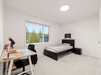 This bright and airy bedroom features a comfortable twin bed with grey linens, perfect for a child or guest.