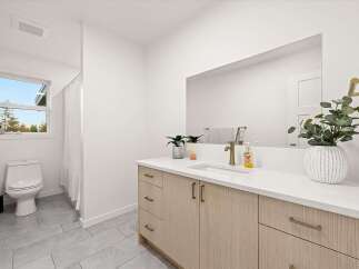 This modern bathroom features a sleek vanity with ample storage and a clean white countertop.