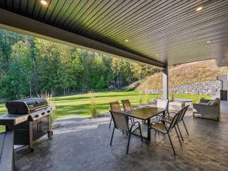 Enjoy outdoor living at its finest on this spacious covered patio, complete with a built-in grill and comfortable seating area.