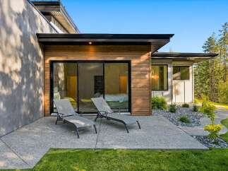 Experience modern luxury with this stunning property featuring a sleek concrete patio and expansive sliding glass doors that seamlessly blend indoor and outdoor living.
