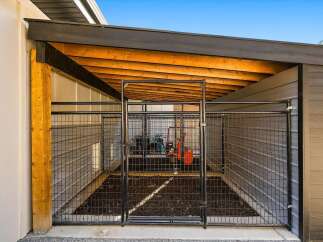 Discover this secure outdoor enclosure, perfect for pets or storage, featuring a durable metal fence and a protective roof.