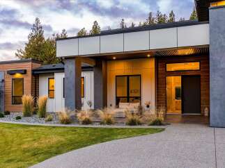Experience modern luxury in this stunning architectural home, featuring a striking facade with natural wood accents and sleek metal paneling.