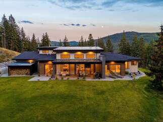 Experience luxury living in this stunning modern home nestled amidst a serene forest landscape.