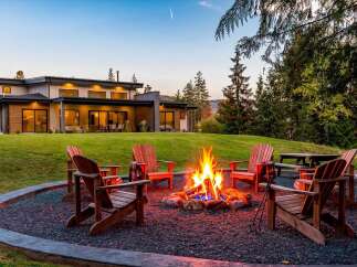 Experience ultimate relaxation in this stunning backyard oasis, complete with a cozy fire pit surrounded by comfortable Adirondack chairs.
