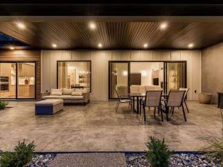 Experience seamless indoor-outdoor living with this stunning patio, featuring a covered ceiling with recessed lighting and ample space for relaxation and dining.