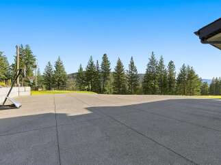Enjoy outdoor recreation with a spacious concrete patio and a basketball hoop, perfect for family fun.