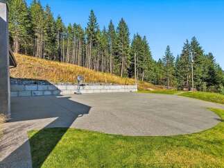 Enjoy outdoor recreation with this spacious paved area, perfect for a basketball court or other activities.