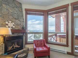 Cozy up by the stone fireplace in this inviting living room, perfect for a mountain getaway.