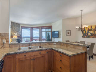 Experience breathtaking mountain views from this stunning kitchen, featuring granite countertops and rich wood cabinetry.