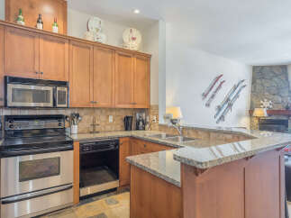 This inviting kitchen boasts beautiful wood cabinetry and granite countertops, perfect for preparing meals.