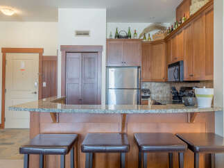 This inviting kitchen features a spacious granite countertop breakfast bar, perfect for casual dining or entertaining guests.