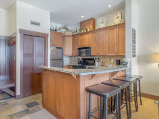 This charming kitchen features warm wood cabinetry and a granite-topped breakfast bar, perfect for casual dining.
