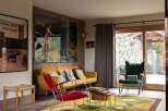 Experience the unique charm of this living space, featuring a vibrant yellow sofa complemented by a striking red accent chair.