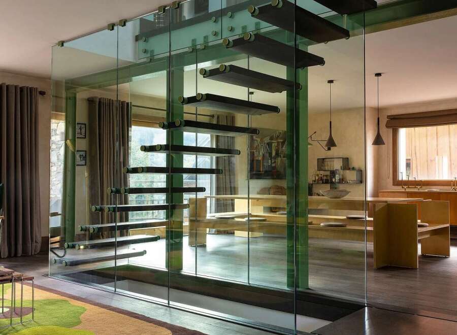Experience modern luxury with this stunning staircase, featuring floating wooden steps encased in sleek glass walls.