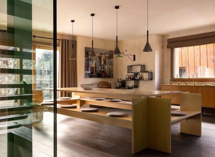 Experience sophisticated dining in this modern space, featuring a unique built-in bench seating arrangement around a sleek wooden table.