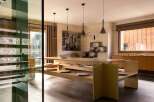 Experience sophisticated dining in this modern space, featuring a unique built-in bench seating arrangement around a sleek wooden table.