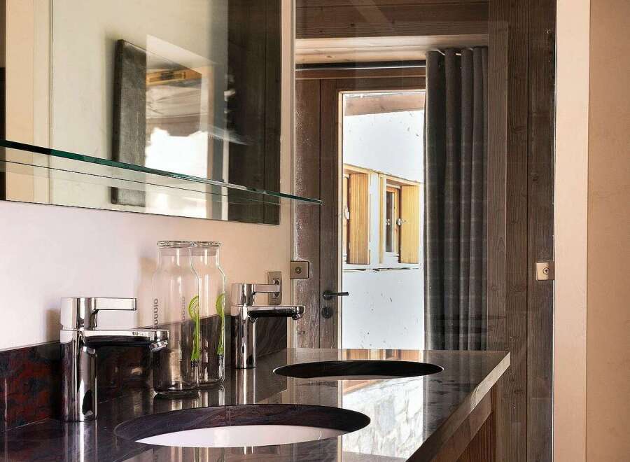 Experience luxury in this modern bathroom featuring a sleek double vanity with granite countertops and contemporary chrome faucets.