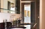 Experience luxury in this modern bathroom featuring a sleek double vanity with granite countertops and contemporary chrome faucets.
