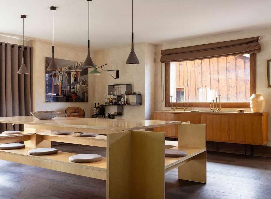 This dining area features a unique, built-in wooden bench seating arrangement with integrated cushions, perfect for casual gatherings.