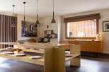 This dining area features a unique, built-in wooden bench seating arrangement with integrated cushions, perfect for casual gatherings.
