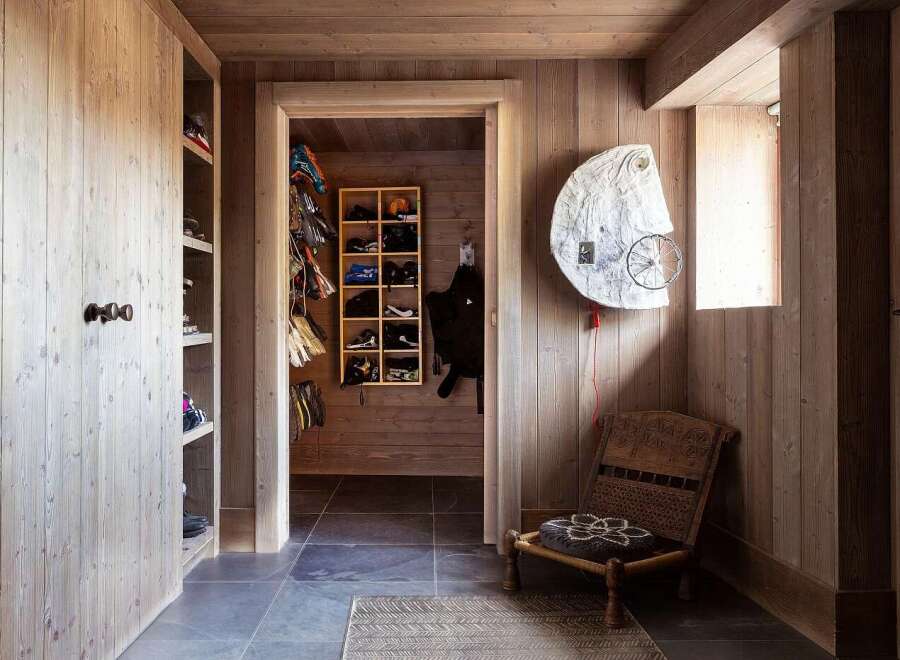 This entryway features a rustic wooden aesthetic with ample storage solutions for outdoor gear.