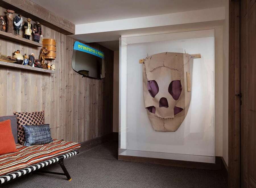 This unique living space features a rustic wooden wall and shelving adorned with charming figurines, creating a whimsical display.