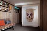 This unique living space features a rustic wooden wall and shelving adorned with charming figurines, creating a whimsical display.