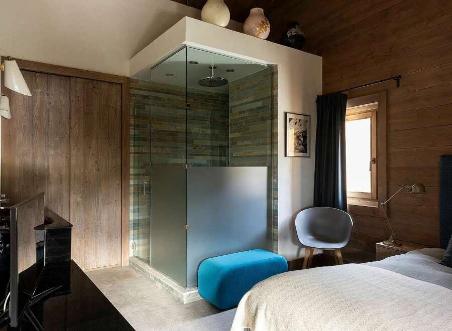 Experience luxury in this master bedroom featuring a stunning glass-enclosed shower with slate tile accents.