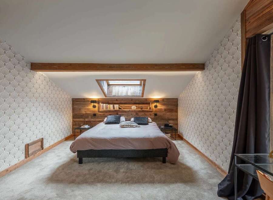 Experience cozy mountain living in this charming bedroom featuring a comfortable bed with plush bedding and a rustic wooden headboard.
