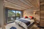 Experience luxury mountain living in this beautifully appointed bedroom featuring a cozy king-sized bed with plush bedding and decorative pillows.